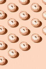 Color of the year 2024 peach fuzz..Shiny disco balls. Creative Christmas pattern. 90s retro party time concept. Xmas holiday background. Top view. Flat lay