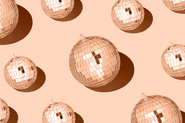 Color of the year 2024 peach fuzz..Shiny disco balls. Creative Christmas pattern. 90s retro party time concept. Xmas holiday background. Top view. Flat lay