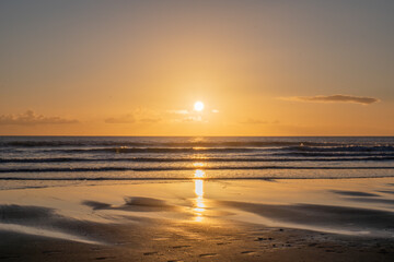 Mesmerizing beach sunset with vibrant colors, tranquil waves, and coastal beauty, ideal for relaxation, travel, golden skies