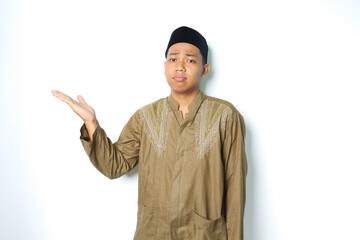 asian muslim man presenting to beside with stressed expression isolated on white background