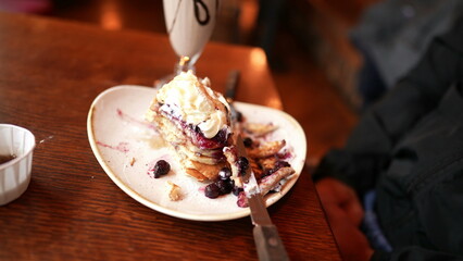 Persone eating and drinking sugarily food dessert at restaurant. Man drinks milkshake and eats plate of pancakes