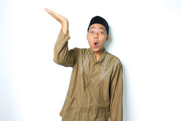 surprised asian muslim man presenting to above with open palm isolated on white background