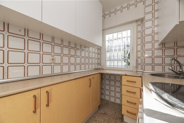 A kitchen with old furniture and tiles