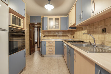 A conventional kitchen furnished with cream and pale blue cabinets