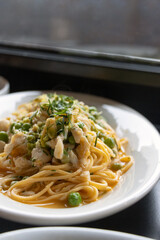 Swimming crab pasta on white plate garnished with green beans