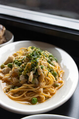 Swimming crab pasta on white plate garnished with green beans