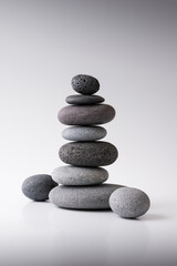 Balancing pebble stones on gray background