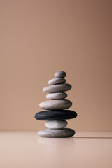 Balancing pebble stones on beige background