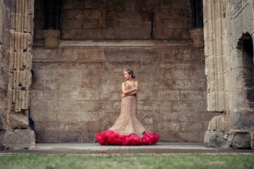 Chica joven rubia con traje flamenco posando en antiguo monasterio