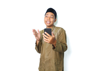 funny asian muslim man using smartphone with raising hand isolated on white background