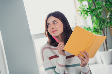 Photo of lovely minded girl hold notebook pen touch chin look curious away contemplate apartment...
