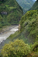 Fototapeta na wymiar River flowing away below the Pailon del Diablo waterfall in Banos, Ecuador