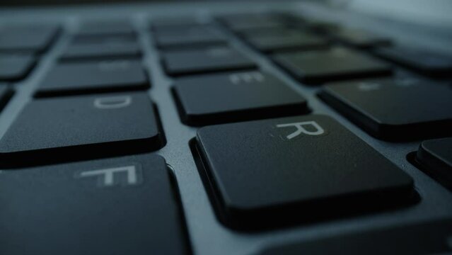 Close up of fingers and hand typing letter message on keyboard.