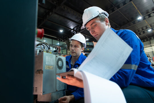 Technician working on the electrical control cabinet of robotic arm, Robotic arms industrial background