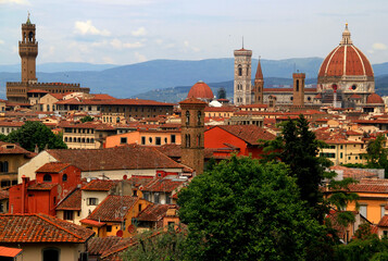 Fototapeta na wymiar Panoramic view of the historic part of Florence with the Cathedral Cattedrale di Santa Maria del Fiore and Palazzo Vecchio building against a background of the mountains in the Tuscany region of Italy