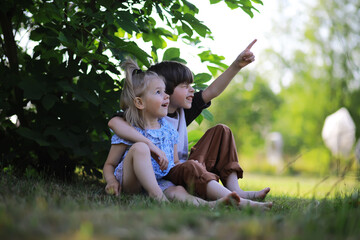 Children walk in the summer in nature. Child on a sunny spring morning in the park. Traveling with...