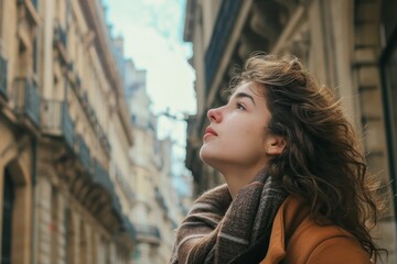 Fototapeta premium A stylish woman gazes thoughtfully at the cityscape from the street, her face framed by a window as she exudes confidence in her fashionable outdoor attire