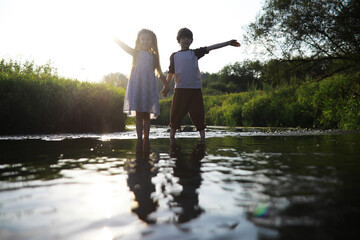Children walk in the summer in nature. Child on a sunny spring morning in the park. Traveling with children.