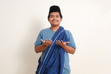 Happy young asian muslim boy standing with praying gesture.