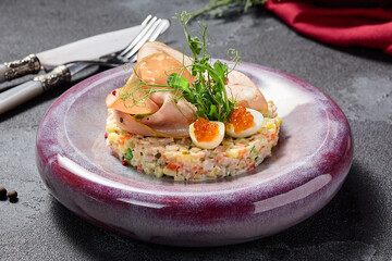 Elegant Olivier salad with mortadella, quail egg, and red caviar, a gourmet twist on a classic dish