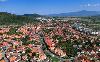 Aerial view of the town of Zărnești in Romania. Located at the foothills of the Piatra Craiului Massif, it's a popular tourist destination for hiking, mountaineering, and winter sports.