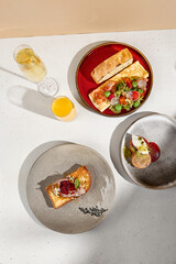 Gourmet Brunch with Omelette, Pate on Brioche Toast, and Cheesecakes with Sparkling Wine and Orange Juice. Top View.