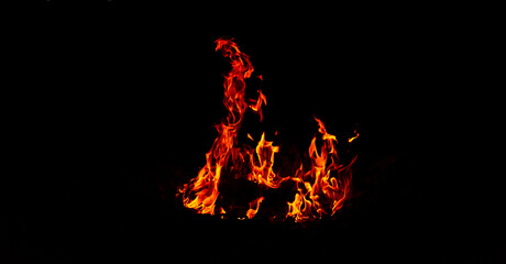Bright flames rising and moving at dark nigh in blurred background.Orange fire flames.Burning red...