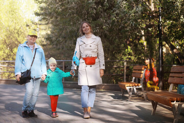 Family with children for a walk in the summer park. Сoming autumn in the park. Family. Fall. Happiness.