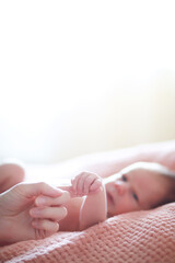 A newborn baby lies in her mother's arms. A beautiful baby of European appearance is sleeping.