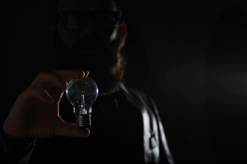 A bearded man in a suit holds an object in his hand. Concept of time and ideas. Aspiration and...