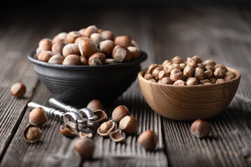 Hazelnuts being opened with a classic silver nutcracker, showcased on an antique wooden table in this captivating food photography