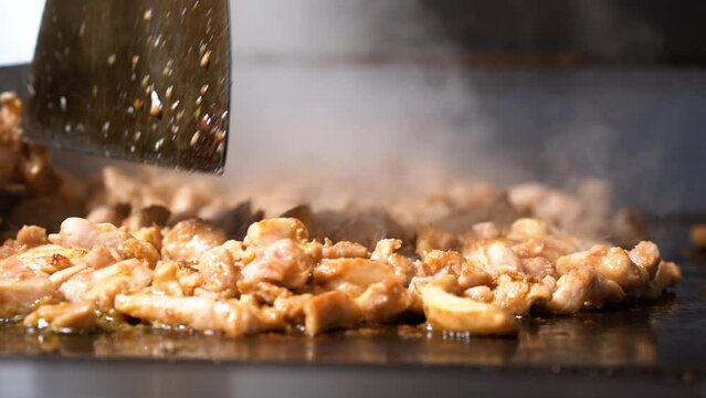 Concept of junk food and eating outdoor. Man cooking meat for traditional wraps from a daytime outdoor street food