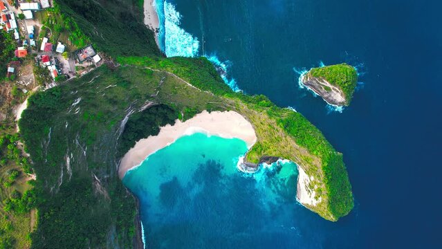 Famous Kelingking T-Rex sightseeing spot landmark at Nusa Penida Island, Bali, Indonesia. Aerial drone footage at daytime surrounded with beautiful ocean waves