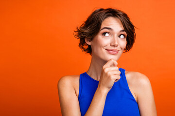 Photo of dreamy adorable lady wear blue singlet arm chin looking empty space isolated orange color background