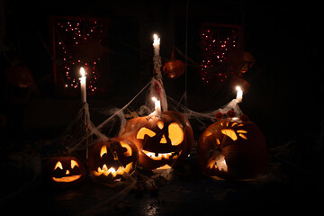 Halloween Jack 'O' Lanterns Installation Background With Spider Nets and Candles Glowing in Darkness
