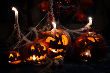 Halloween Jack 'O' Lanterns Installation Background With Spider Nets and Candles Glowing in Darkness