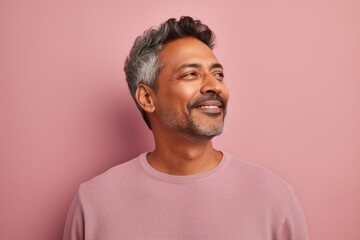 Portrait of a blissful indian man in his 40s wearing a thermal fleece pullover against a pastel or...