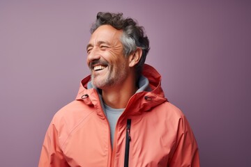 Fototapeta na wymiar Portrait of a joyful man in his 50s wearing a windproof softshell against a pastel or soft colors background. AI Generation
