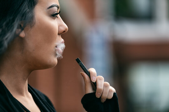 Adult Female Vaping With An E-Cigarette