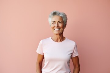 Portrait of a smiling woman in her 70s wearing a moisture-wicking running shirt against a pastel or soft colors background. AI Generation