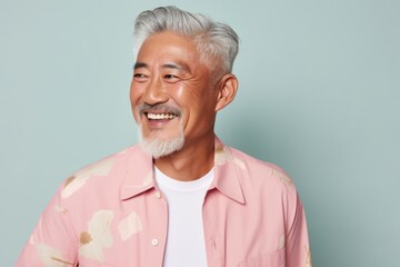 Portrait of a content asian man in his 60s donning a trendy cropped top against a pastel or soft...