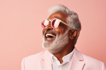 Portrait of a joyful indian man in his 60s wearing a trendy sunglasses against a pastel or soft...