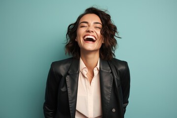 Portrait of a jovial woman in her 20s sporting a stylish leather blazer against a pastel or soft...