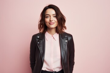 Portrait of a jovial woman in her 20s sporting a stylish leather blazer against a pastel or soft...