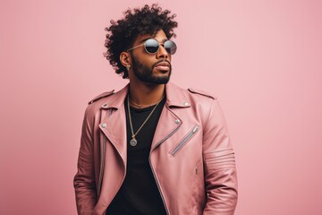 Portrait of a glad afro-american man in his 20s sporting a classic leather jacket against a pastel...