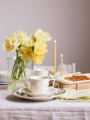 Breakfast table for two with yellow tulips and candles
