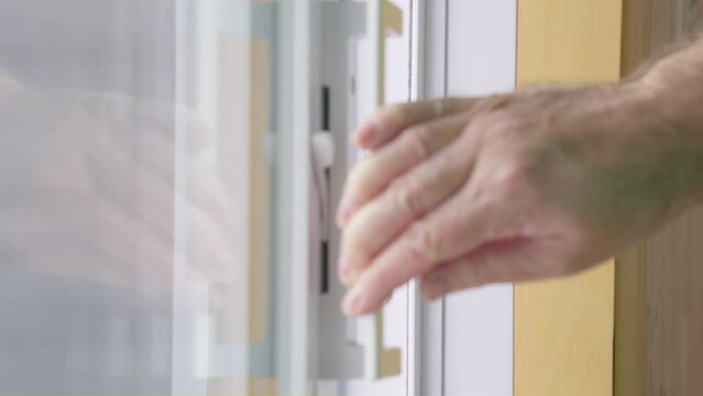 Men hand closed and locked a sliding patio door