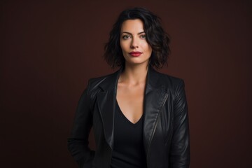 Portrait of a tender woman in her 30s sporting a stylish leather blazer against a solid color backdrop. AI Generation