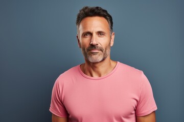 Obraz premium Portrait of a tender man in his 40s dressed in a casual t-shirt against a solid color backdrop. AI Generation