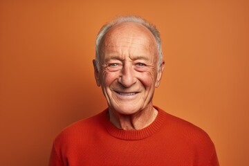 Obraz premium Portrait of a grinning man in his 80s showing off a thermal merino wool top against a solid color backdrop. AI Generation